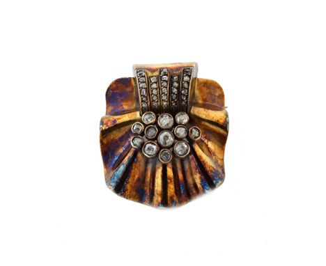 A gold and diamond brooch, in a fanned and ridged design, in the Art Deco taste, mounted with variously cut diamonds, circa 1