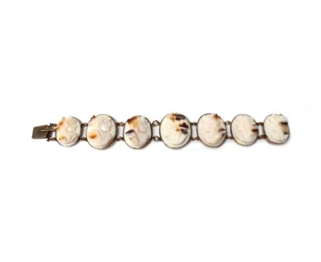 A shell cameo bracelet, designed as a row of seven graduated oval cameos, each carved as the portrait of a classical lady, on