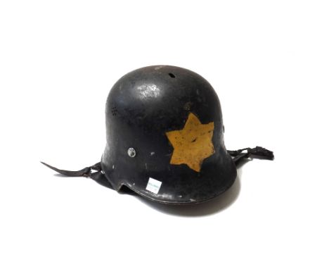A German World War II Luftschutz fire helmet, black painted with air vents, black leather chin strap and leather lining, with