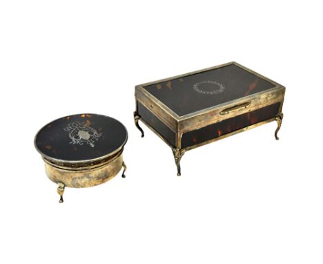 A silver mounted tortoiseshell rectangular hinge lidded trinket box, the lid with a wreath motif, otherwise raised on four be