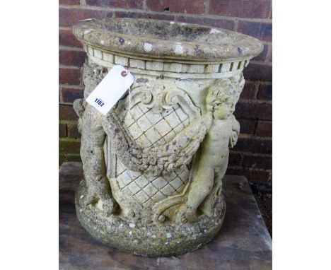 A large reconstituted stone planter of conical form, relief cast with swags intertwined with back to back cherubs, 55cm wide 
