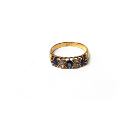 An 18ct gold, sapphire and diamond ring, mounted with three oval cut sapphires and with four diamonds of various cuts mounted