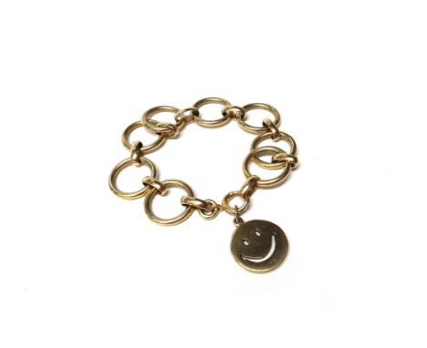 A gold circular and oval link bracelet, detailed 14 K, on a boltring clasp, with a gold circular pendant, pierced as a smiley