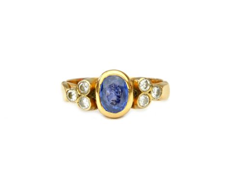 A gold, sapphire and diamond ring, mounted with the oval cut sapphire at the centre, between circular cut diamond set three s