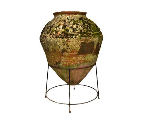 A massive terracotta oil jar, with wriggle work band decoration and iron cradle, approximately 140cm high.  Illustrated