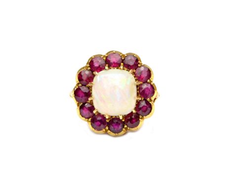 A gold, opal and ruby set cluster ring, mounted with the cushion shaped opal at the centre, in a surround of twelve cushion s