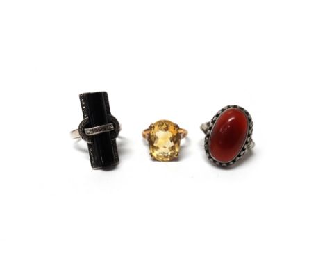 A gold ring, claw set with an oval cut citrine, detailed 9 CT gold, a black onyx and marcasite set silver ring and a cornelia