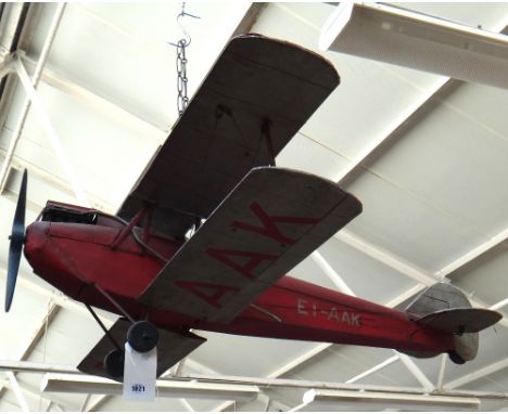 A scale model biplane, mid 20th century, metal and wood, red and silver painted with adjustable moving parts, 120cm.