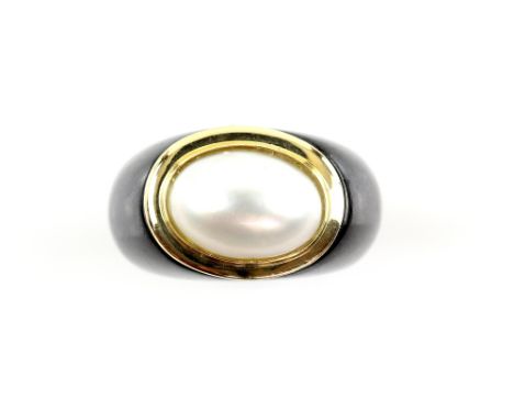 Mabe pearl ring, bevelled mount stamped 14 ct, in black hard stone shank, ring size K 1/2 Gross weight 9.9 grams