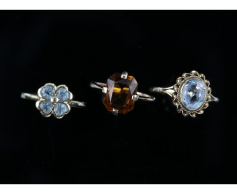Three gem set rings, one set with an oval cut aquamarine, estimated weight 1.56 carats, size P, another set with four heart c