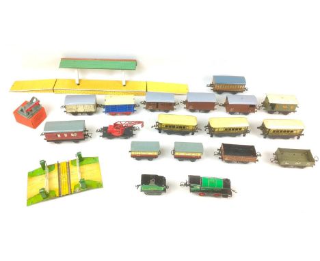 A collection of vintage Hornby O gauge railway models, including a clockwork loco and tender, carriages, rolling stock, stati