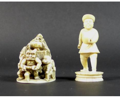 A Meiji period ivory netsuke, formed as a cart being pulled by a demon, with three further zoomorphic figures and a lady with