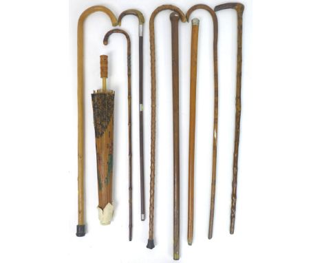 A collection of eight walking sticks, including a briarwood stick, some with carved handles, together with a malacca cane wit