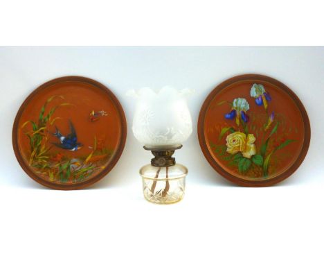 A pair of Watcombe Torquay terracotta chargers, one decorated with a swallow flying amongst reeds and butterflies, the other 
