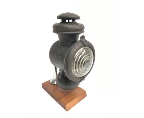 Ford Model T cowl lamp with bulls eye lens. Height 23cm, lens diameter 9cm. Mounted on display plinth. 