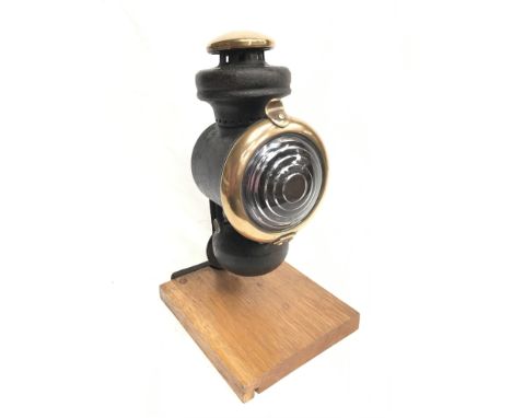 Ford Model T cowl lamp with brass parts and bulls eye lens. Height 23cm, lens diameter 9cm. Mounted on display plinth. 