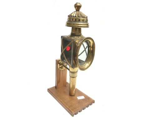 Victorian brass carriage lamp with clear beveled glass, red rear glass lens, and mounting bracket. Height 45cm. Mounted on di