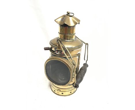 Nautical brass signal lamp with reflective glass, containing brass burner and with wooden handle, height 22cm. 
