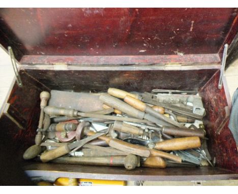A pine tool chest containing various chisels, planes, drills and other wood working tools