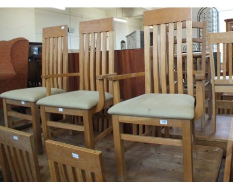A set of ten modern light oak dining chairs (including two carvers) with cream upholstered seats