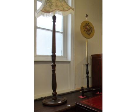 A rosewood and brass pole fire screen with floral tapestry circular screen and a wooden standard lamp
