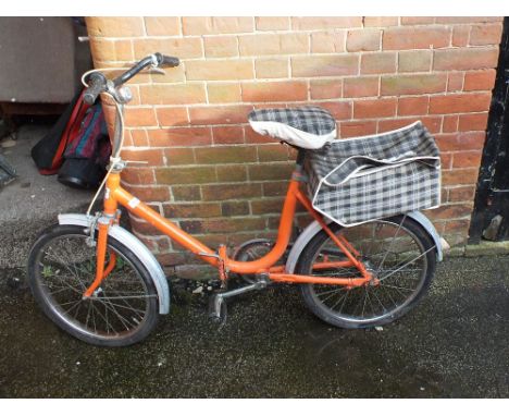 A vintage orange Marken Grandezza Rader folding bicycle