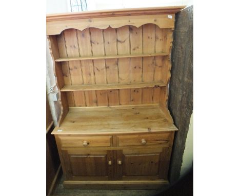 A light pine two door, two drawer shelf back dresser