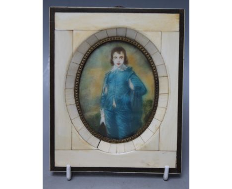 A 20TH CENTURY OVAL PORTRAIT MINIATURE ON IVORINE depicting a boy in a blue satin suit, unsigned, framed in a decorative bone