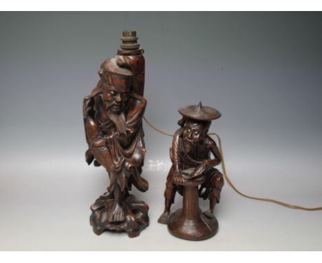 AN ORIENTAL CARVED HARDWOOD FIGURE DEPICTED AS A FISHERMAN, made into a lamp, H 36 cm, together with another smaller carved f