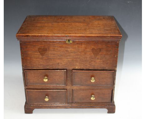A 19TH CENTURY APPRENTICE MULE CHEST, the hinged lid above two heart shaped inlaid lozenges, with four drawers below, raised 