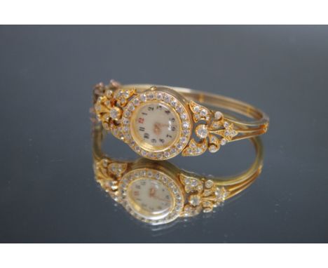 A LADIES DIAMOND SET BANGLE WRIST WATCH, set with approx 1.75 carats of brilliant cut diamonds, inner casing stamped .750, Di