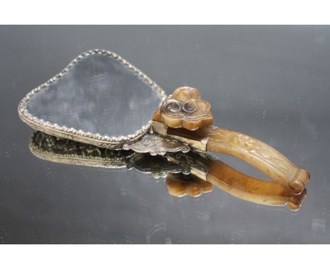 A CHINESE JADE HANDLED WHITE METAL HAND MIRROR, the handle of traditional belt hook form, overall L 21 cm