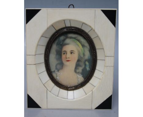 A 20TH CENTURY OVAL PORTRAIT MINIATURE ON IVORINE, depicting a young woman with ribbon in her hair, unsigned, framed in a dec
