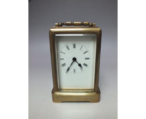 A VINTAGE BRASS CARRIAGE CLOCK OF SMALL PROPORTIONS, the five glass case of simplistic form, the white enamel dial with Roman