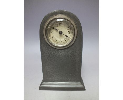 A LIBERTY &amp; CO ENGLISH PEWTER MANTEL CLOCK, the domed case of simple form, raised on a stepped base, circular dial with A