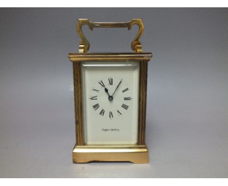 A MAPPIN &amp; WEBB BRASS CASED CARRIAGE CLOCK, having a white enamel dial with Roman numerals, bevelled glass windows and pr