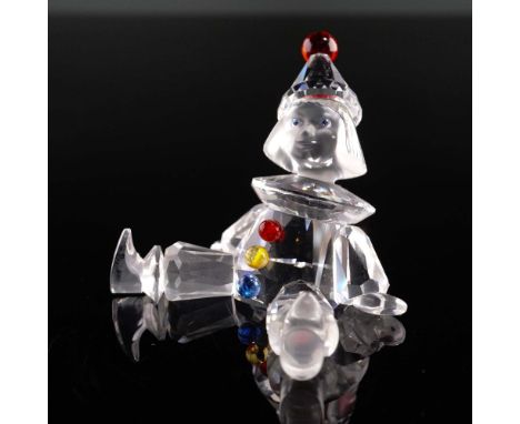This whimsical Swarovski Crystal Puppet figurine features a clear crystal body with a frosted face, vibrant blue eyes, and a 