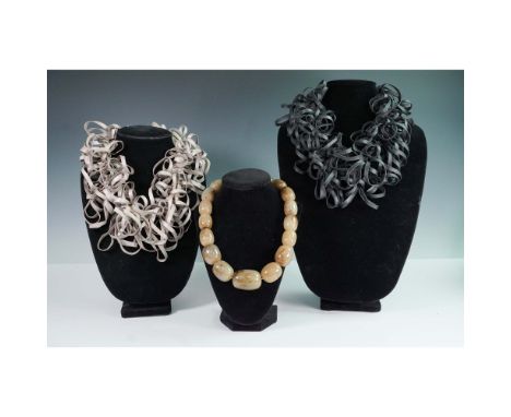Group of three fashion statement necklaces including two sculptural looped ribbon designs in matte plastic-one in charcoal gr