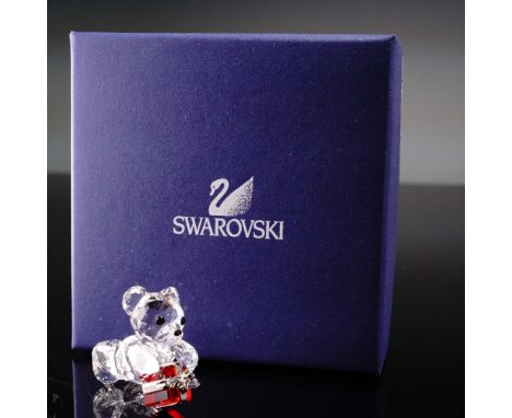 This Swarovski crystal figurine features the beloved Kris Bear presenting a sparkling red crystal gift box with silver-tone r