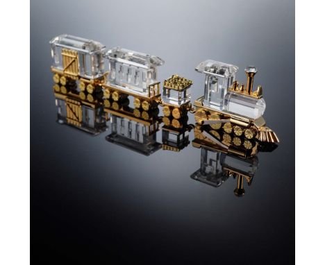 This charming 3-piece train set from the Swarovski Crystal Memories collection includes a clear crystal locomotive, freight c