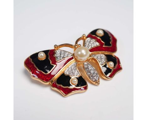 A vintage butterfly brooch adorned with red and black enamel wings, clear rhinestones, and faux pearls, all set in gold tone 