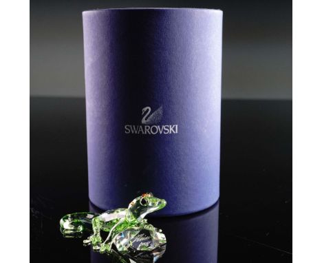 Captivating Swarovski Crystal figurine depicting a vibrant green gecko with red crystal eyes, poised elegantly atop a multifa