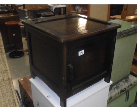 A 1930s oak commode pot cupboard with undersized enamel pot