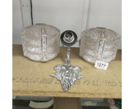 A pair of art deco lamp shades and a chromed brass rams head wall light.