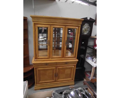 A light wood display cabinet with cupboard base