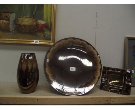 A Poole pottery charger, vase and ashtray