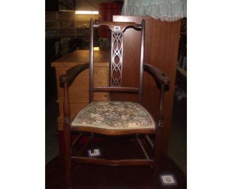 An Edwardian inlaid carver arm chair with floral tapestry seat