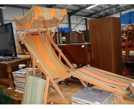 A vintage deck chair with sun cover and one other.