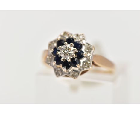 A 9CT GOLD SAPPHIRE AND DIAMOND CLUSTER RING, of tiered design, set with a central single cut diamond within a claw set circu