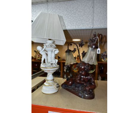 A BRONZED RESIN TABLE LAMP IN THE FORM OF A CHERUB, signed Itassi, twin shades with leaf decoration, height approximately 53c